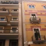 Foto 9. Fiancheggiamo piazza Umberto e all�incrocio con via Beatillo notiamo un elegantissimo e ristrutturato palazzo dagli accesi colori giallo e rosa, contiguo a uno smorto stabile verdastro con geometrici balconi neri 